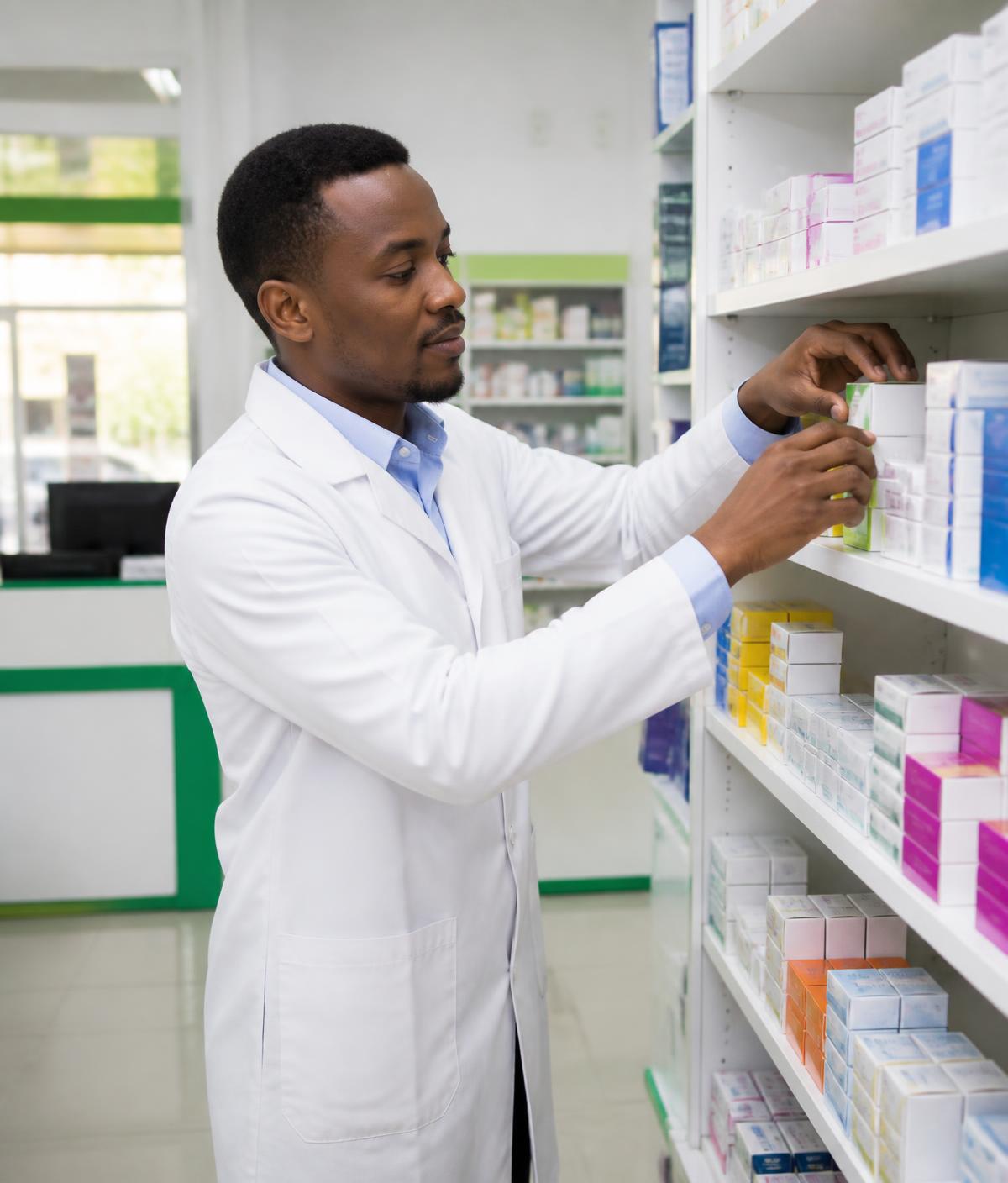A pharmacist organizing products on clean pharmacy shelves